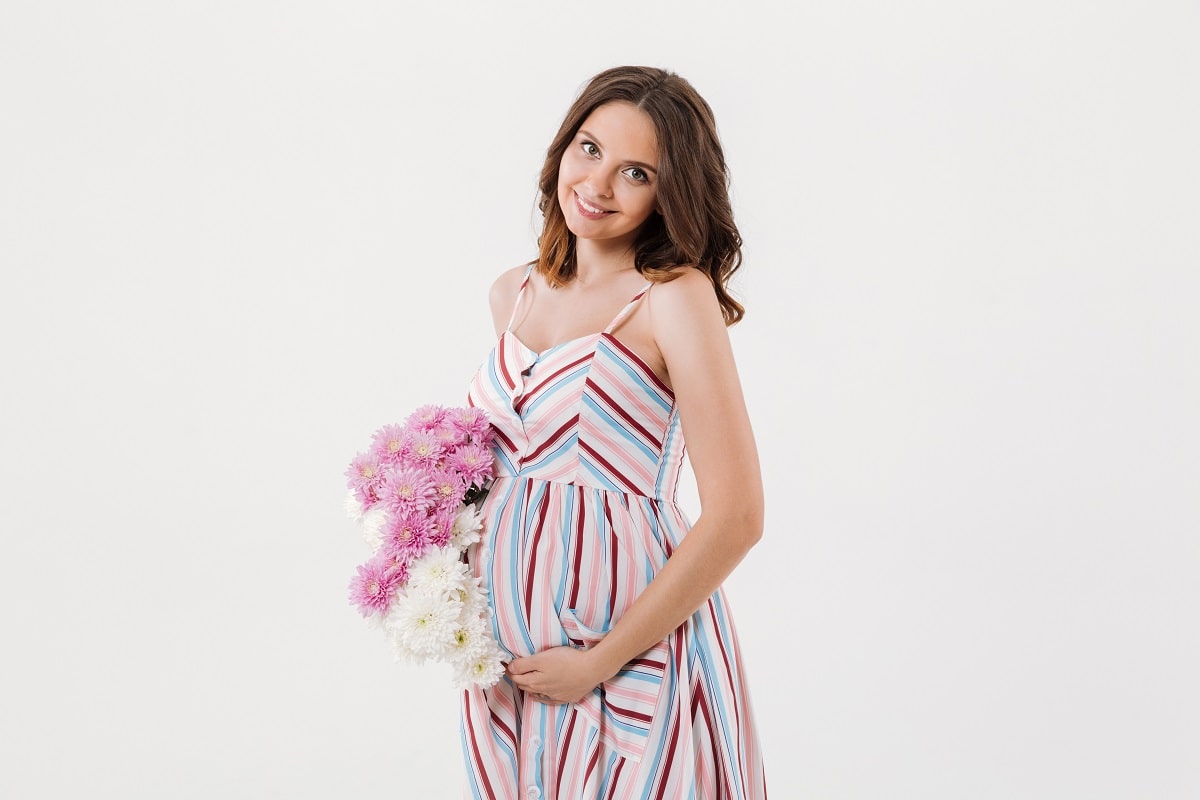 Беременная девушка с букетом цветов - календарь беременности